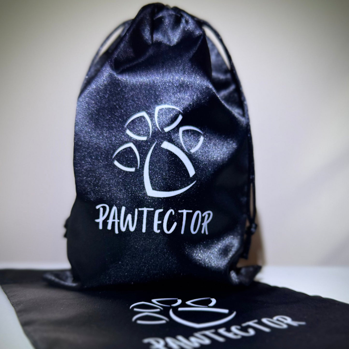 Black satin Pawtector pouch for storing CarpiFlex dog wrist wraps – drawstring style